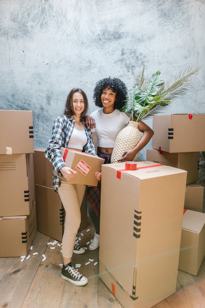 A happy couple packing boxes inside their new home, surrounded by moving supplies.